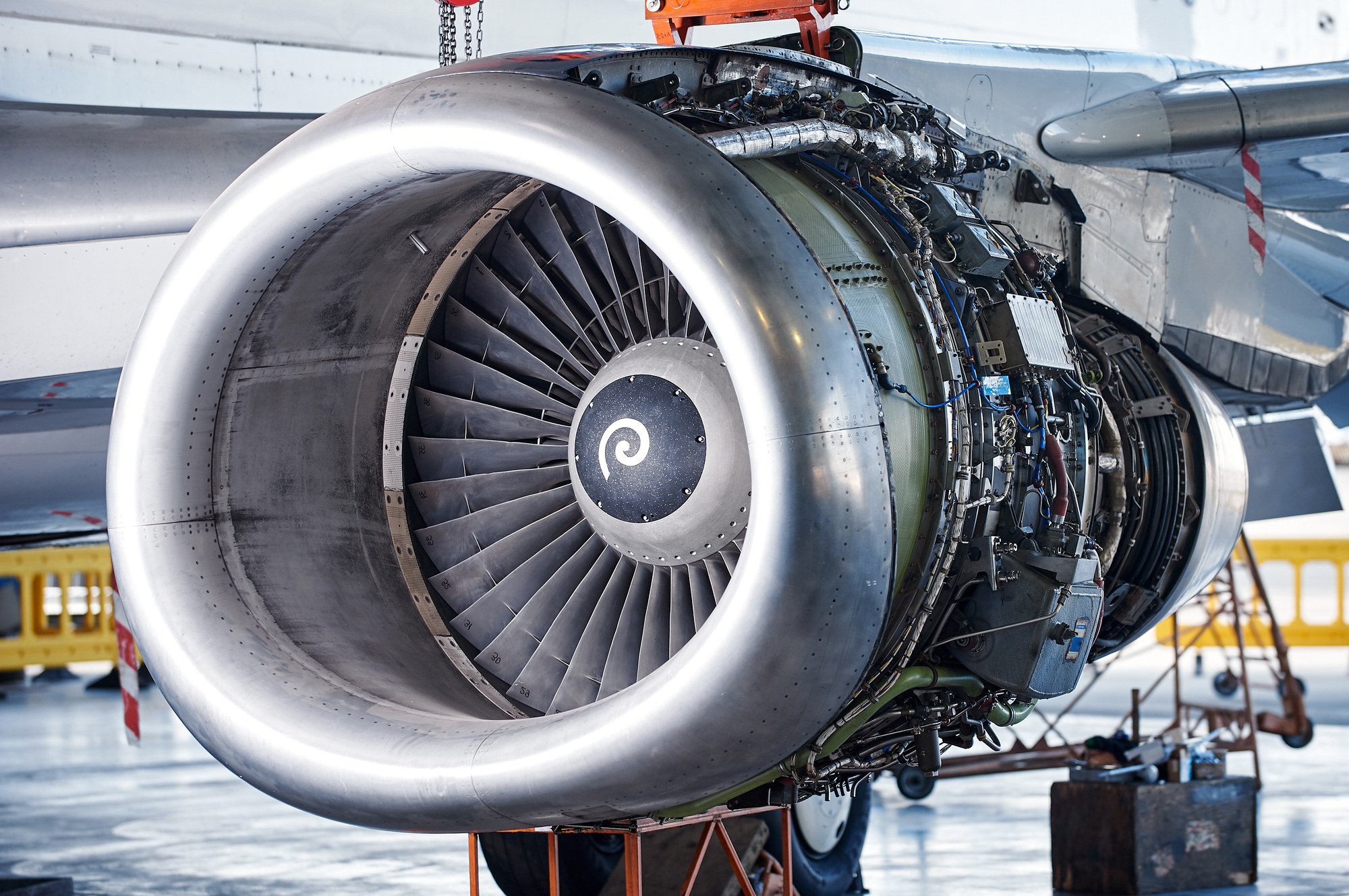 aircraft engine servicing - opened panels of a large engine of parked aircraft.